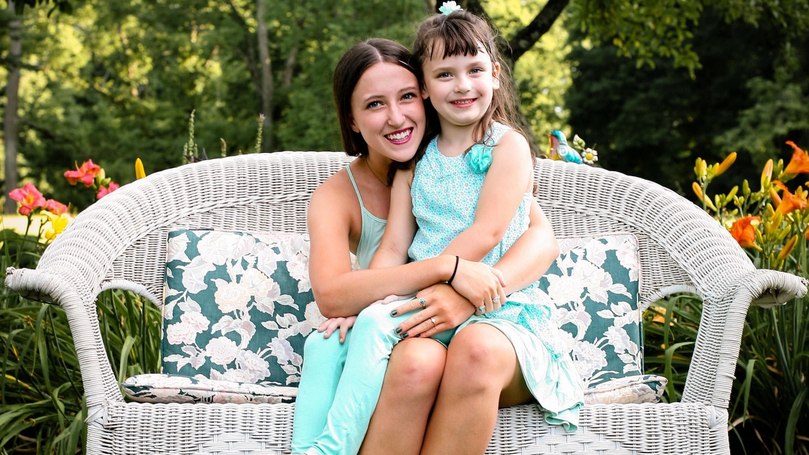 Woman sitting with little girl on bench