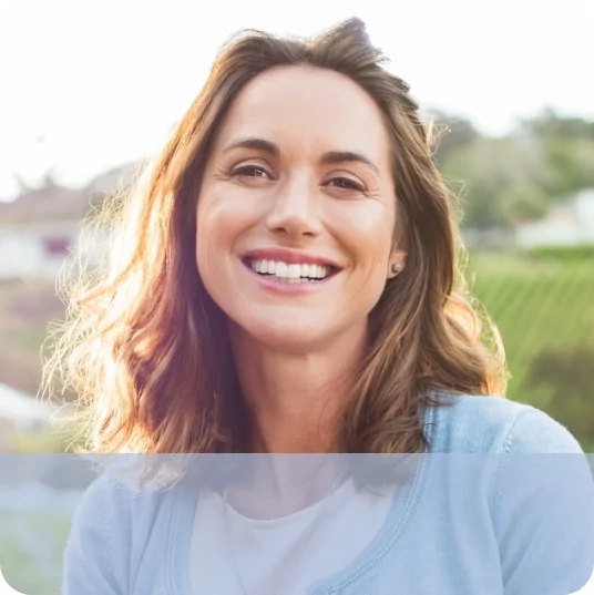 Young woman smiling in front of sunset