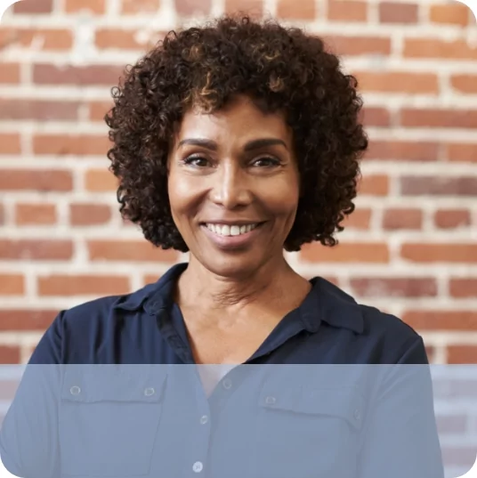 Older woman in front of bricks