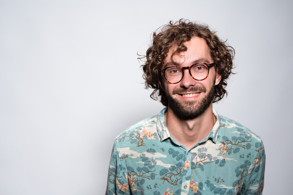 Man with curly hair and glasses