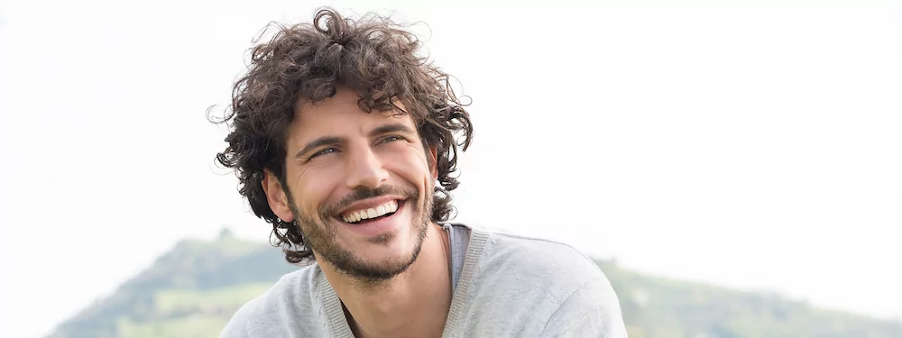 Man with curly hair smiling