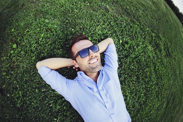 Man smiling while laying in grass